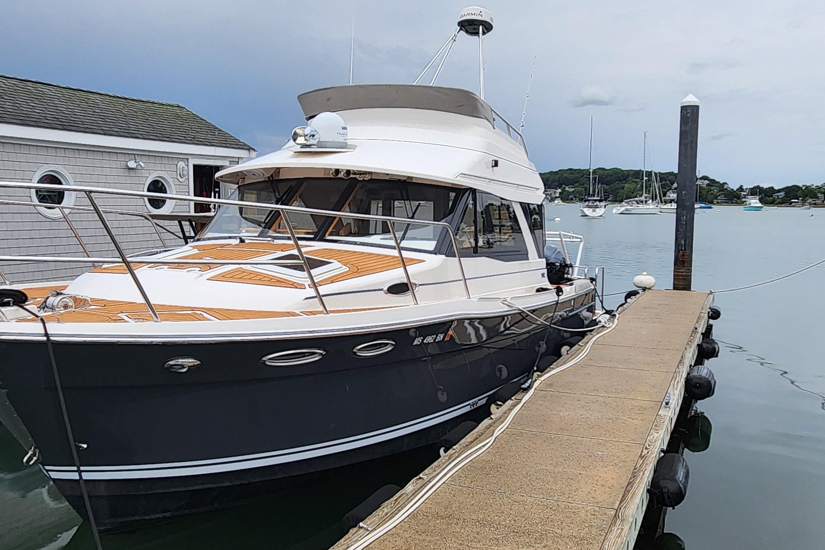 Cutwater C-32 CB 2020 Cutwater C-32 CB boat docked at marina, calm waters, overcast sky.