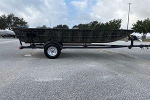 Tracker Grizzly 1754 Utility 2026 Tracker Grizzly 1754 Utility boat on trailer in parking lot.