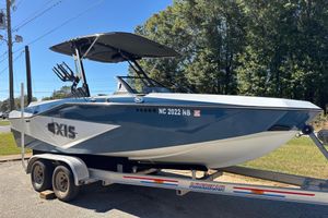 Axis T220 2023 Axis T220 boat on trailer, parked outdoors, with trees in the background.