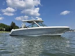 Boston Whaler 320 Vantage 2023 Boston Whaler 320 Vantage boat on calm water under blue sky.