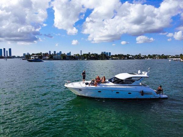 Carver 440 Hardtop Express 2000 Carver 440 Hardtop Express yacht cruising on a sunny day with city skyline backdrop.