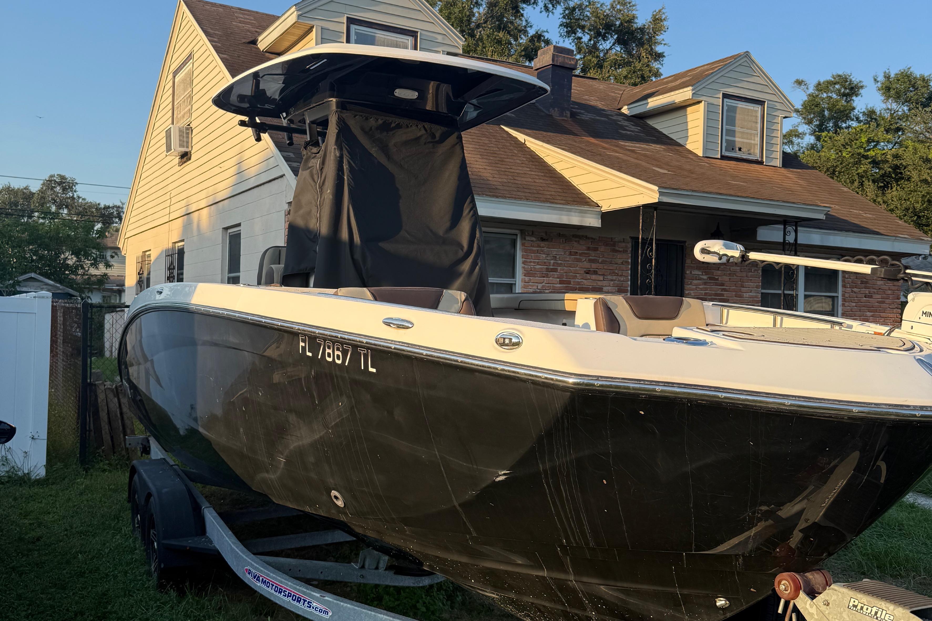 Yamaha Boats 255 FSH Sport E 2023 Yamaha Boats 255 FSH Sport E on trailer, parked beside a house.