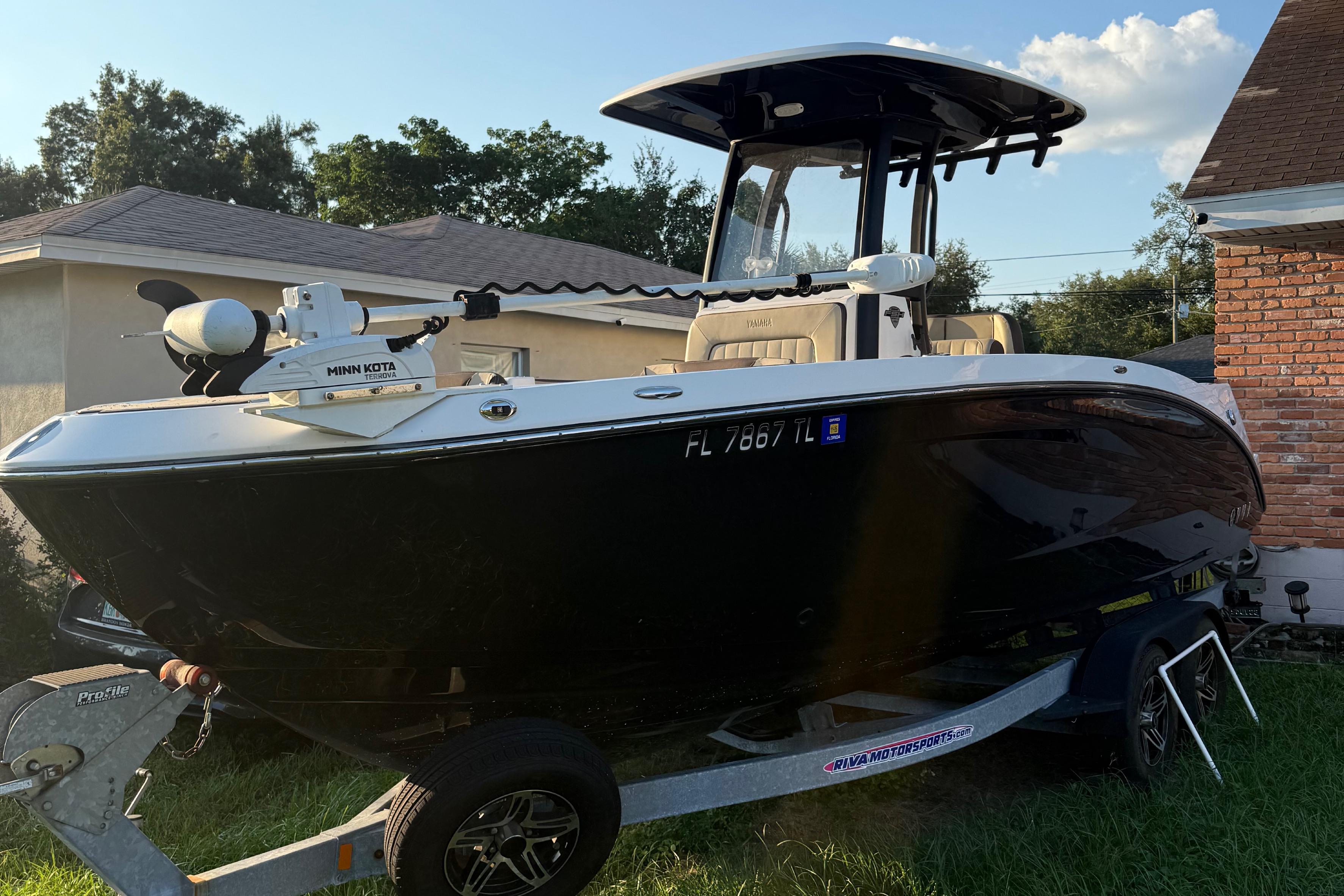 Yamaha Boats 255 FSH Sport E 2023 Yamaha Boats 255 FSH Sport E on trailer, parked beside a house.