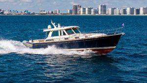 Sabre 48 Salon Express 2015 Sabre 48 Salon Express yacht cruising on blue ocean near city skyline.