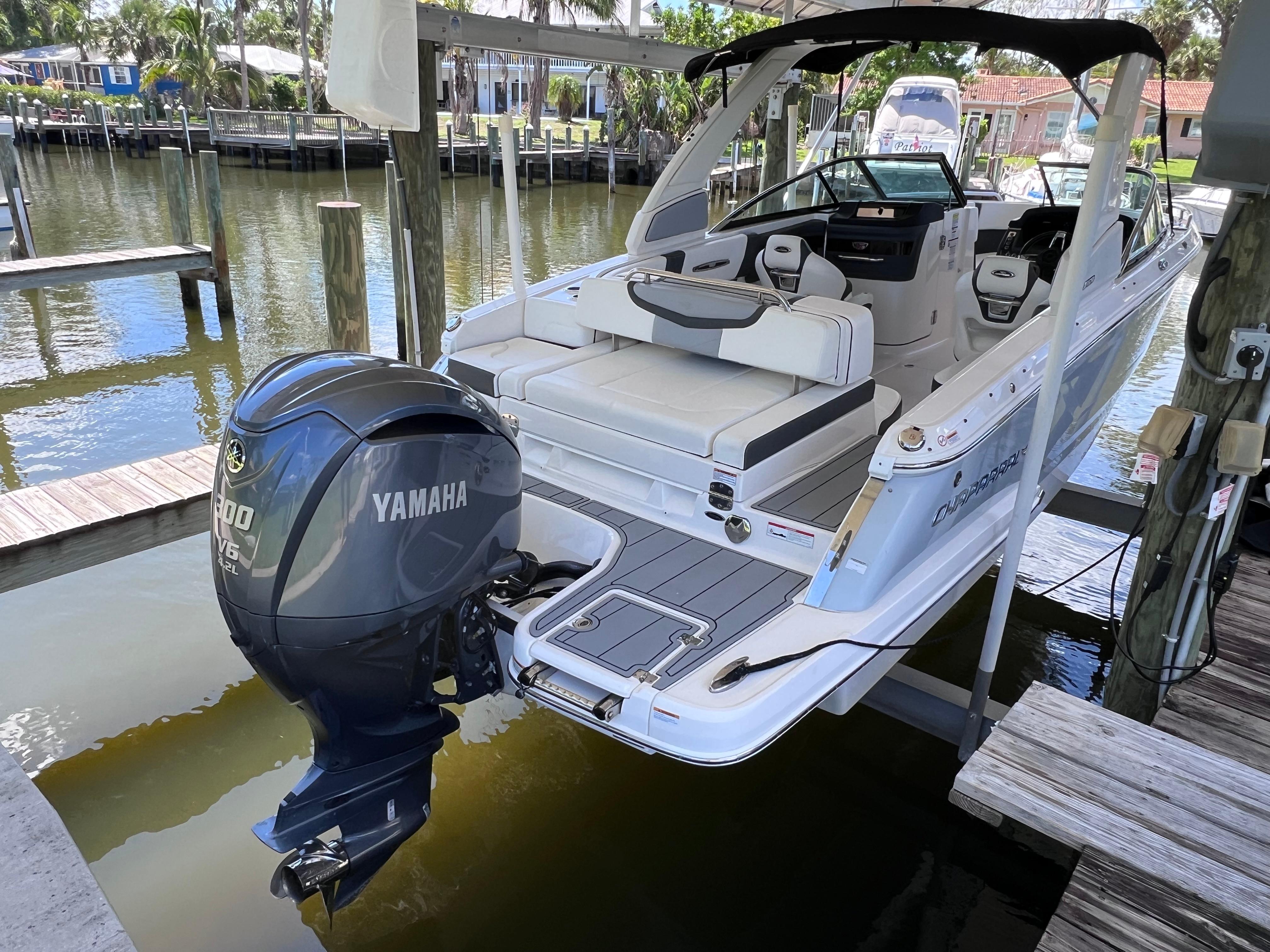 Chaparral 267 SSX OB 2022 Chaparral 267 SSX OB boat with Yamaha outboard motor docked by waterfront.