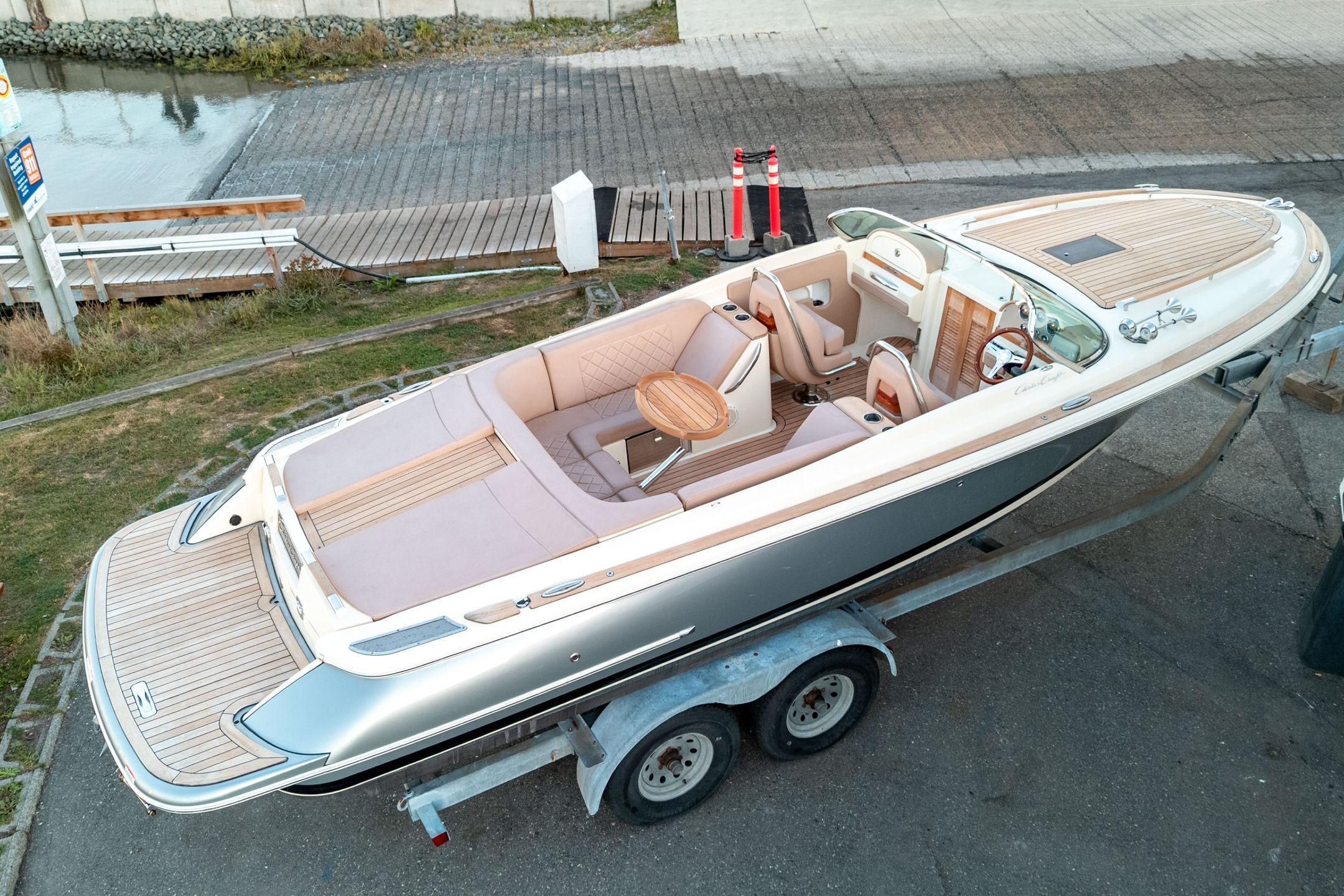 Chris-Craft Corsair 27 2018 Chris-Craft Corsair 27 boat on trailer, featuring elegant design and spacious seating.