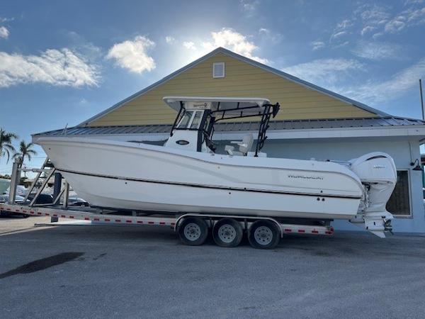 World Cat 295 CC 2025 World Cat 295 CC boat on trailer, parked near a building under a blue sky.