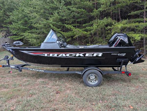 Tracker Pro Guide V-16 WT 2025 Tracker Pro Guide V-16 WT boat on trailer, parked on grass with forest background.