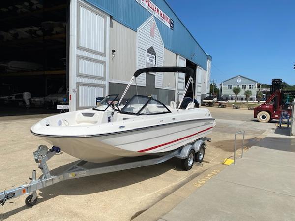 Bayliner Element E21 2024 Bayliner Element E21 boat on trailer outside a marina.