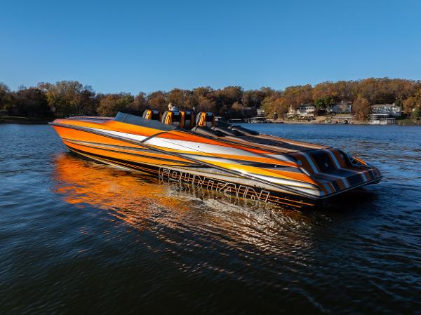 Fountain 47 Lightning 2020 Fountain 47 Lightning speedboat with vibrant orange and black design on a calm lake.