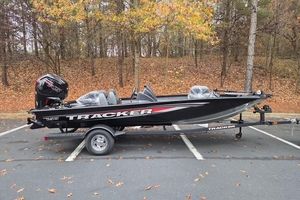 Tracker Pro Team 190 2026 Tracker Pro Team 190 boat on trailer in wooded parking area.