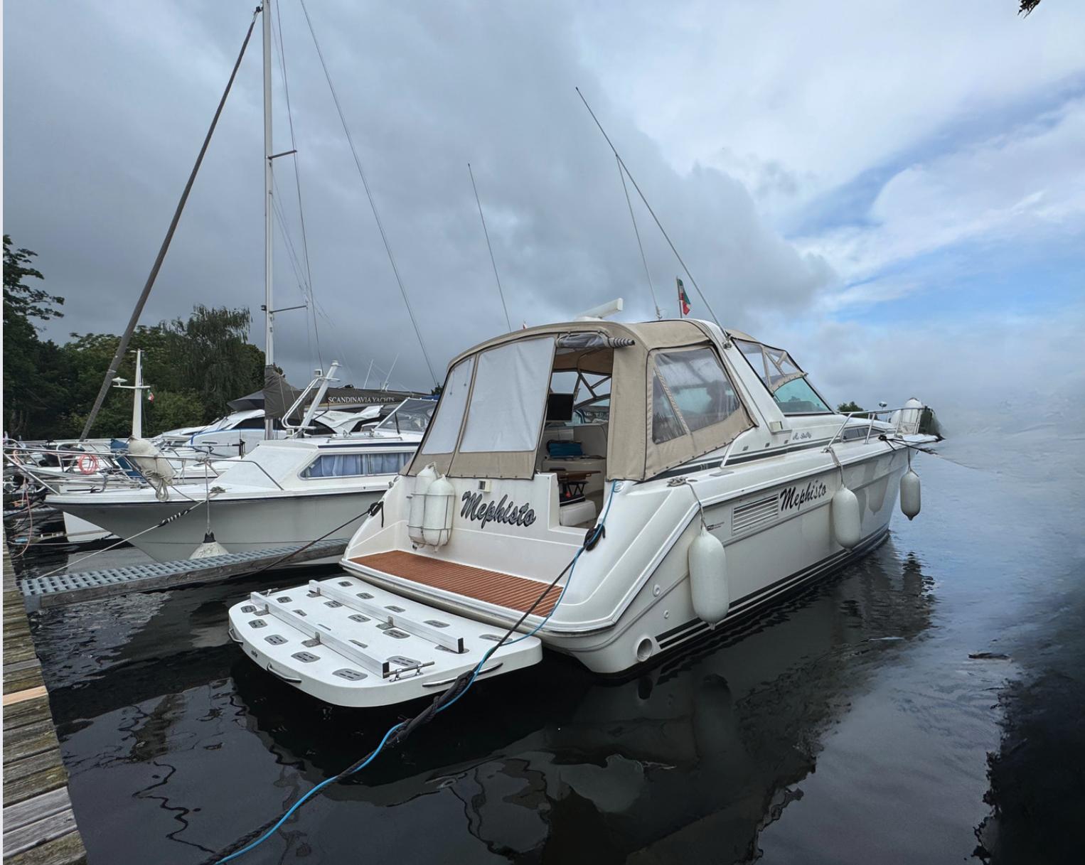 Sea Ray 350 Express Cruiser 1991 Sea Ray 350 Express Cruiser docked at marina, overcast sky.