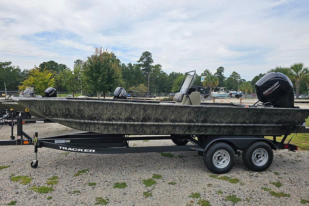 Tracker Grizzly 2072 CC 2026 Tracker Grizzly 2072 CC boat on trailer, parked outdoors with trees in background.