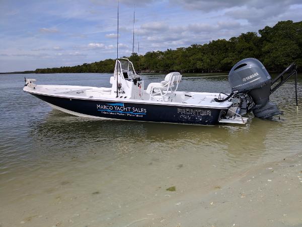 Frontier 2104 A 2017 Frontier 2104 boat with Yamaha motor, docked on a sandy shore.