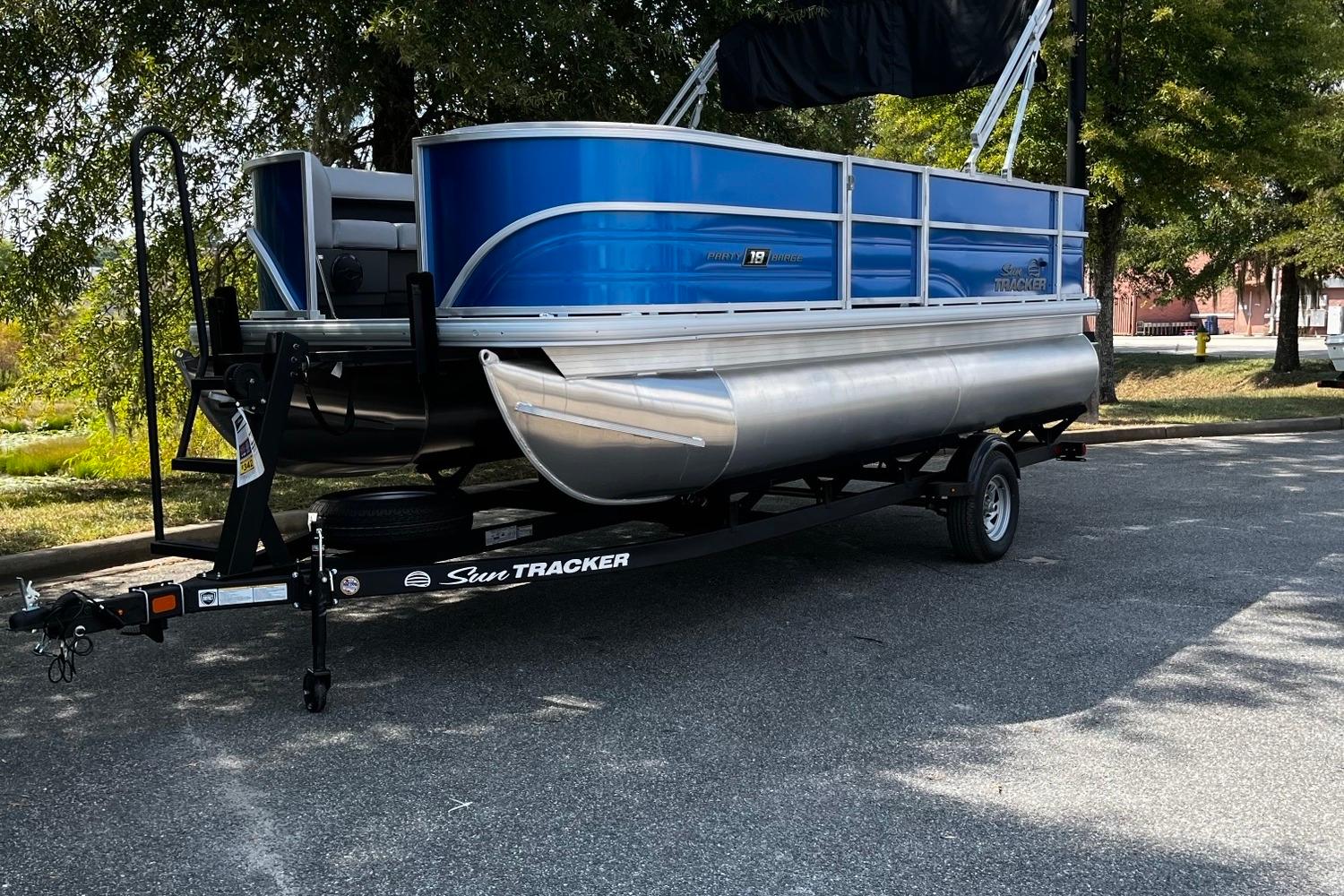 Sun Tracker Party Barge 18 DLX 2026 Sun Tracker Party Barge 18 DLX pontoon boat on trailer, parked outdoors.
