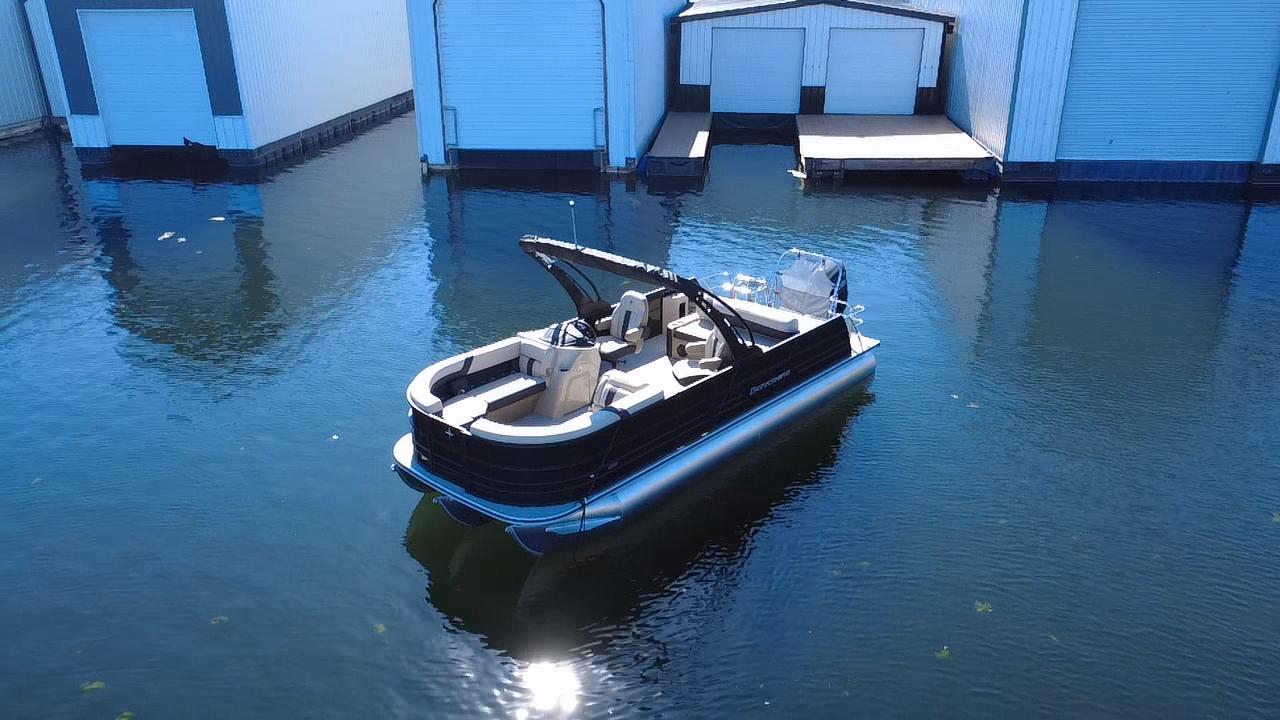 Berkshire CTS Series 24UL 2026 Berkshire CTS Series 24UL pontoon boat docked near boathouses on calm water.