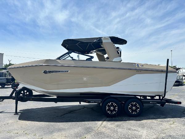 Nautique Super Air Nautique G23 2025 Nautique Super Air Nautique G23 boat on trailer, beige and white, under clear sky.