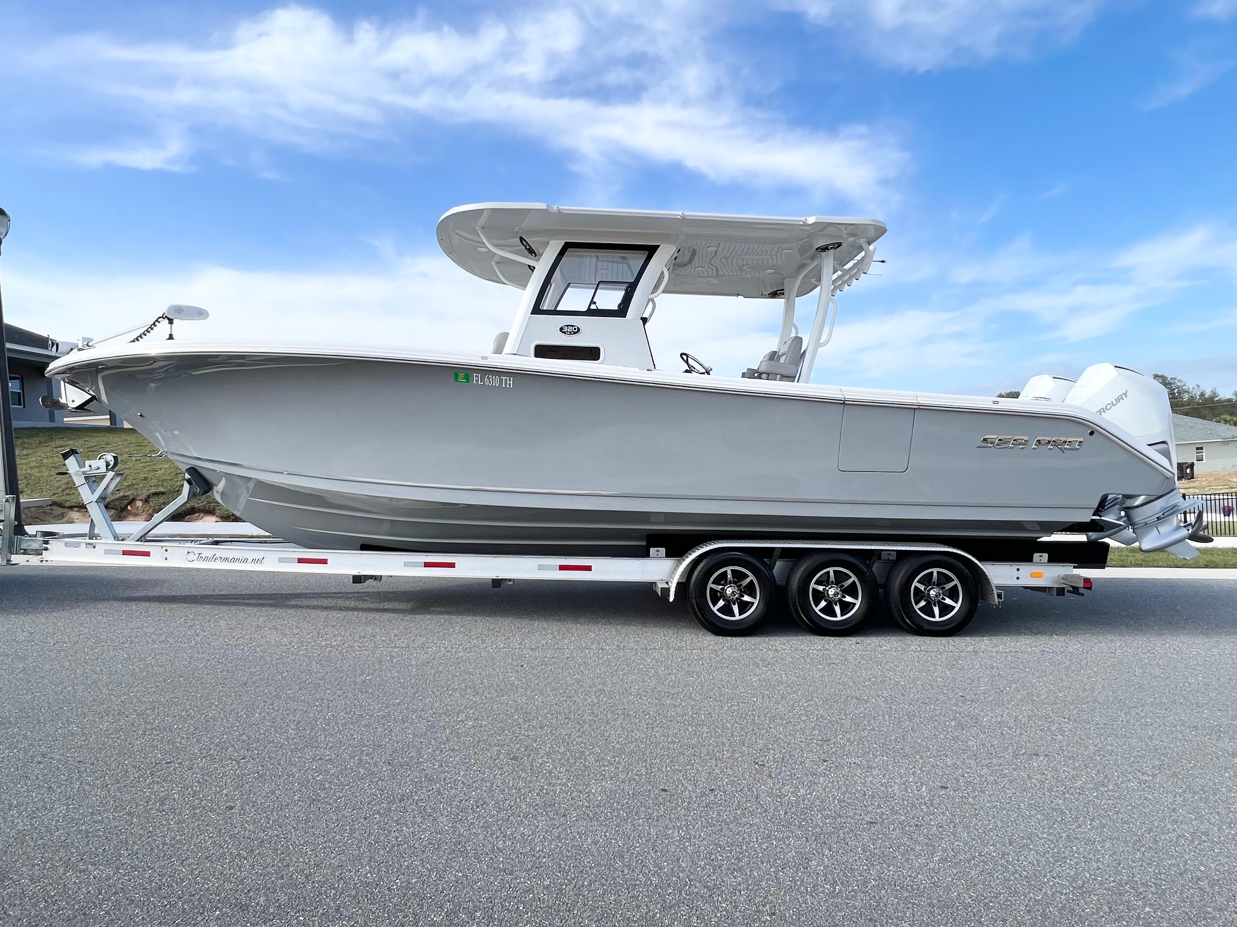 Sea Pro 320 DLX Offshore 2022 Sea Pro 320 DLX Offshore boat on trailer, side view, under clear blue sky.