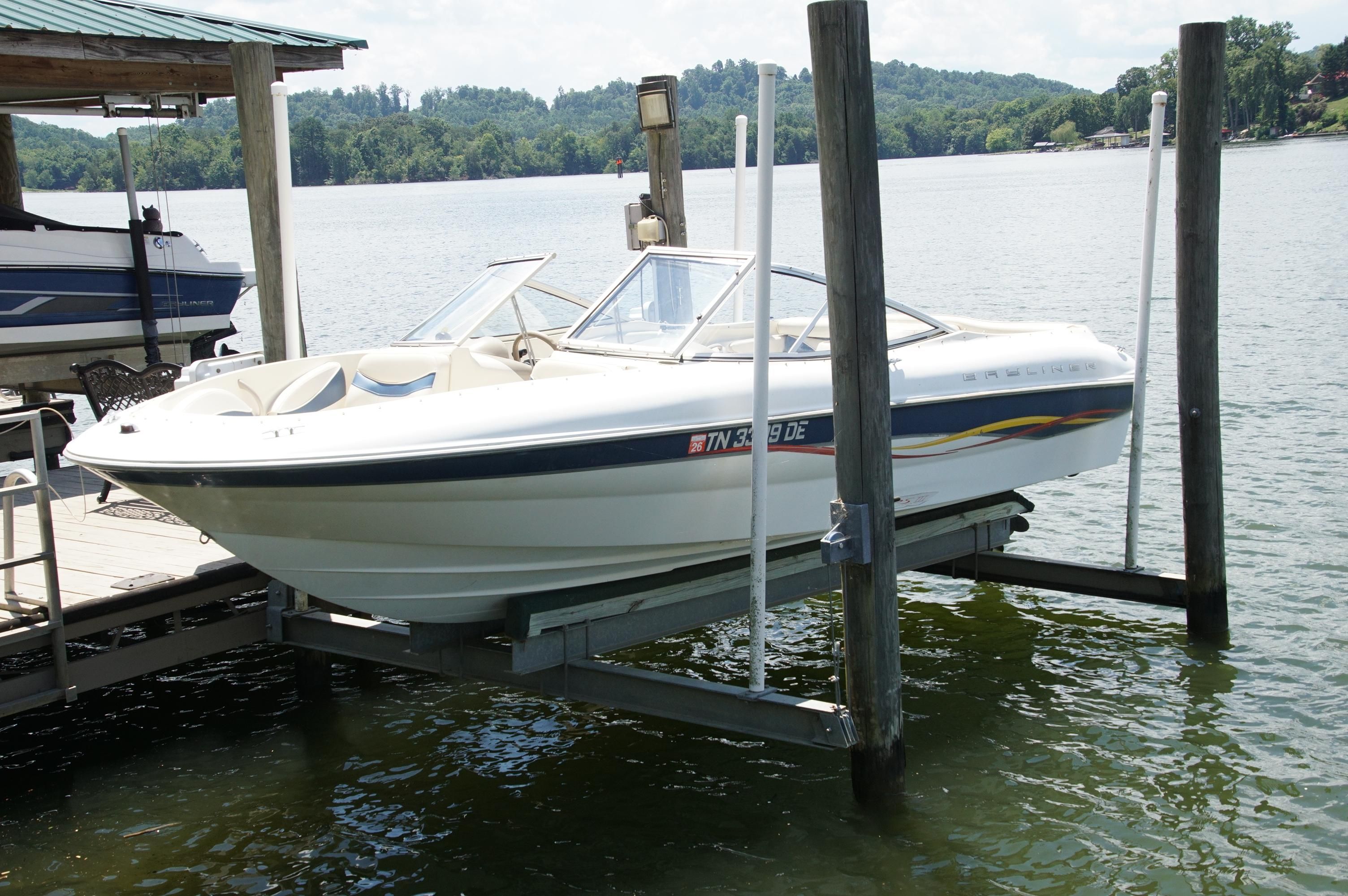 Bayliner Capri 2150LX 2001 Bayliner Capri 2150LX boat on lift by lakeside dock.