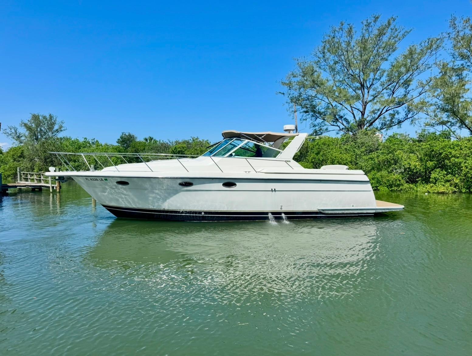 Tiara Yachts 3500 Express 1998 Tiara Yachts 3500 Express cruising on a serene waterway, surrounded by lush greenery.