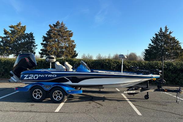 Nitro Z20 2023 Nitro Z20 boat in parking lot, blue and white design, on trailer.