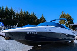 Sea Ray 240 Sundancer 2013 Sea Ray 240 Sundancer boat on display, covered, with trees in the background.