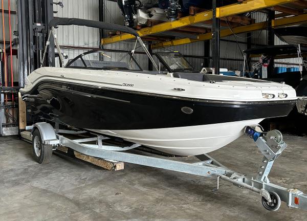 Bayliner DX 2000 2024 Bayliner DX 2000 boat on a trailer in a storage facility.