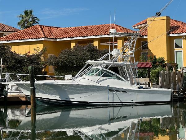Luhrs Express 2002 Luhrs Express boat docked by colorful waterfront homes.