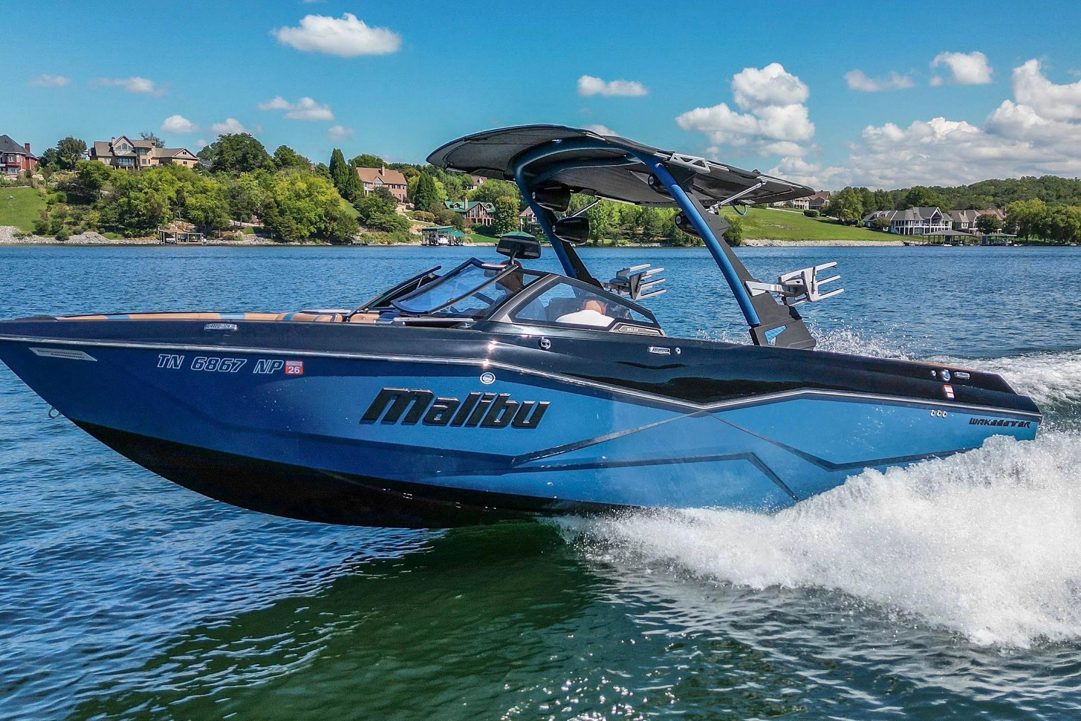 Malibu Wakesetter 25 LSV 2022 Malibu Wakesetter 25 LSV boat cruising on a scenic lake.