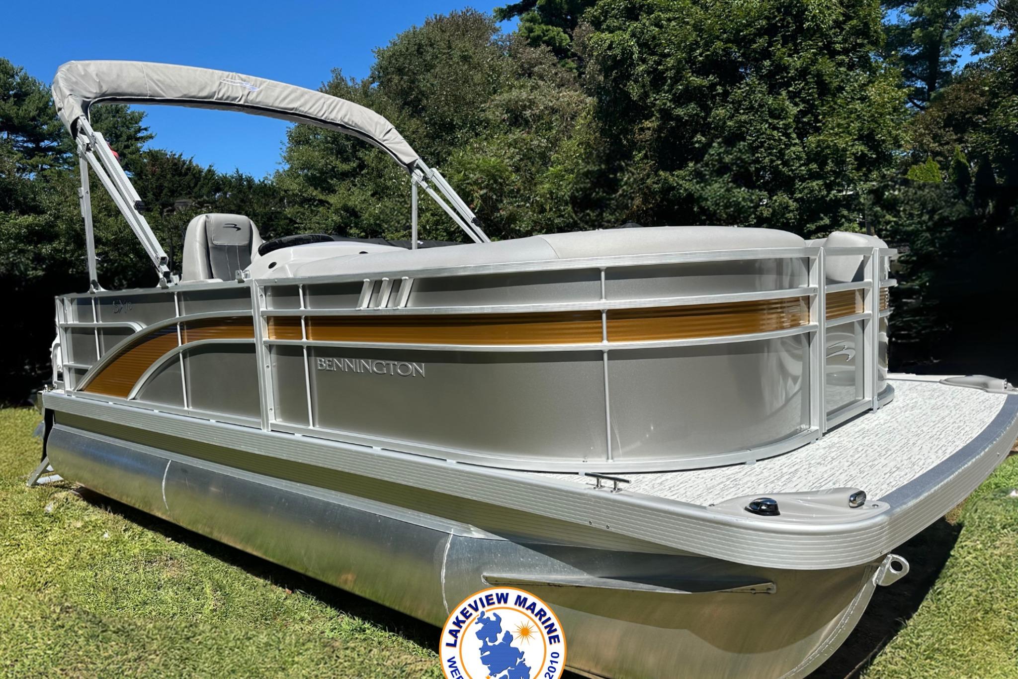 Bennington 18 SXL 2025 Bennington 18 SXL pontoon boat on grass with trees in background.