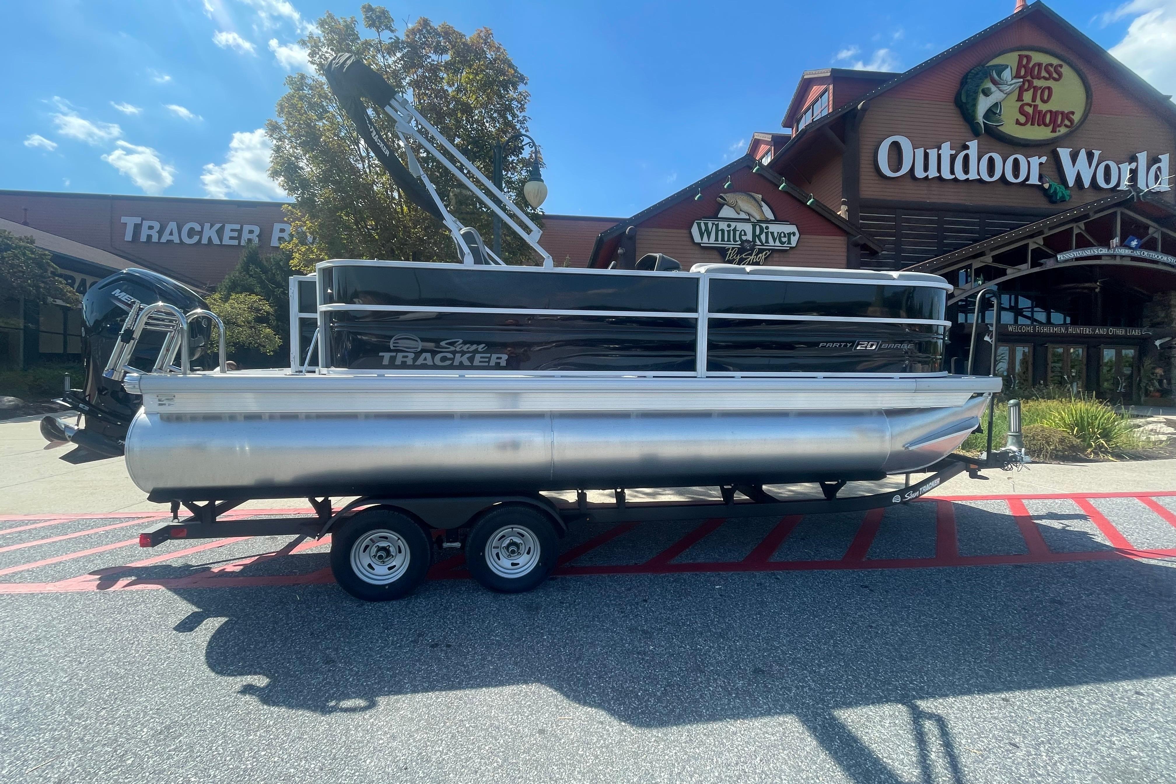 Sun Tracker Party Barge 20 DLX 2026 Sun Tracker Party Barge 20 DLX pontoon boat outside Bass Pro Shops.