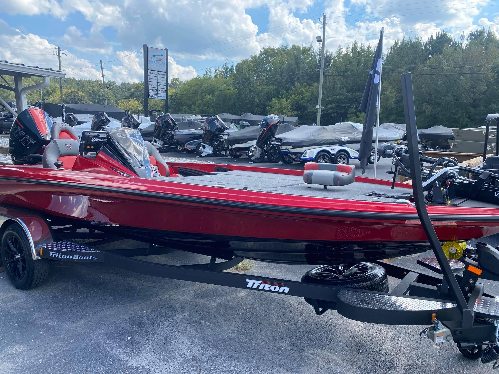 Triton 21XP Patriot 2025 Triton 21XP Patriot boat in vibrant red on a trailer, displayed outdoors.