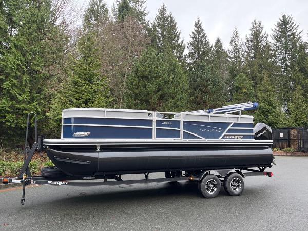 Ranger Reata 223C 2024 Ranger Reata 223C pontoon boat on a trailer, parked near a forested area.