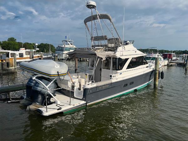 Cutwater C-32 CB 2021 Cutwater C-32 CB boat docked at marina, featuring inflatable dinghy and outboard motor.