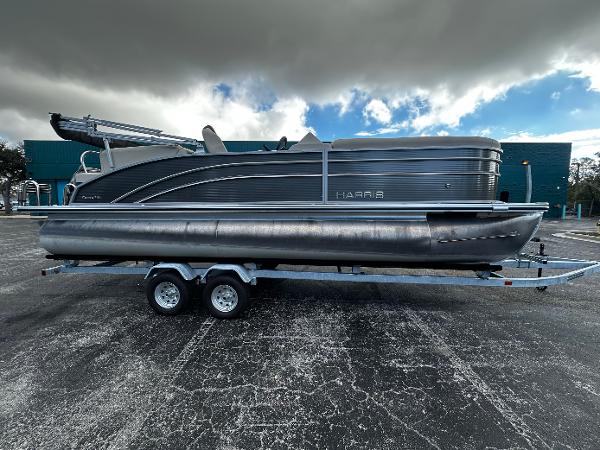 Harris Cruiser 230 2023 Harris Cruiser 230 pontoon boat on trailer under cloudy sky.