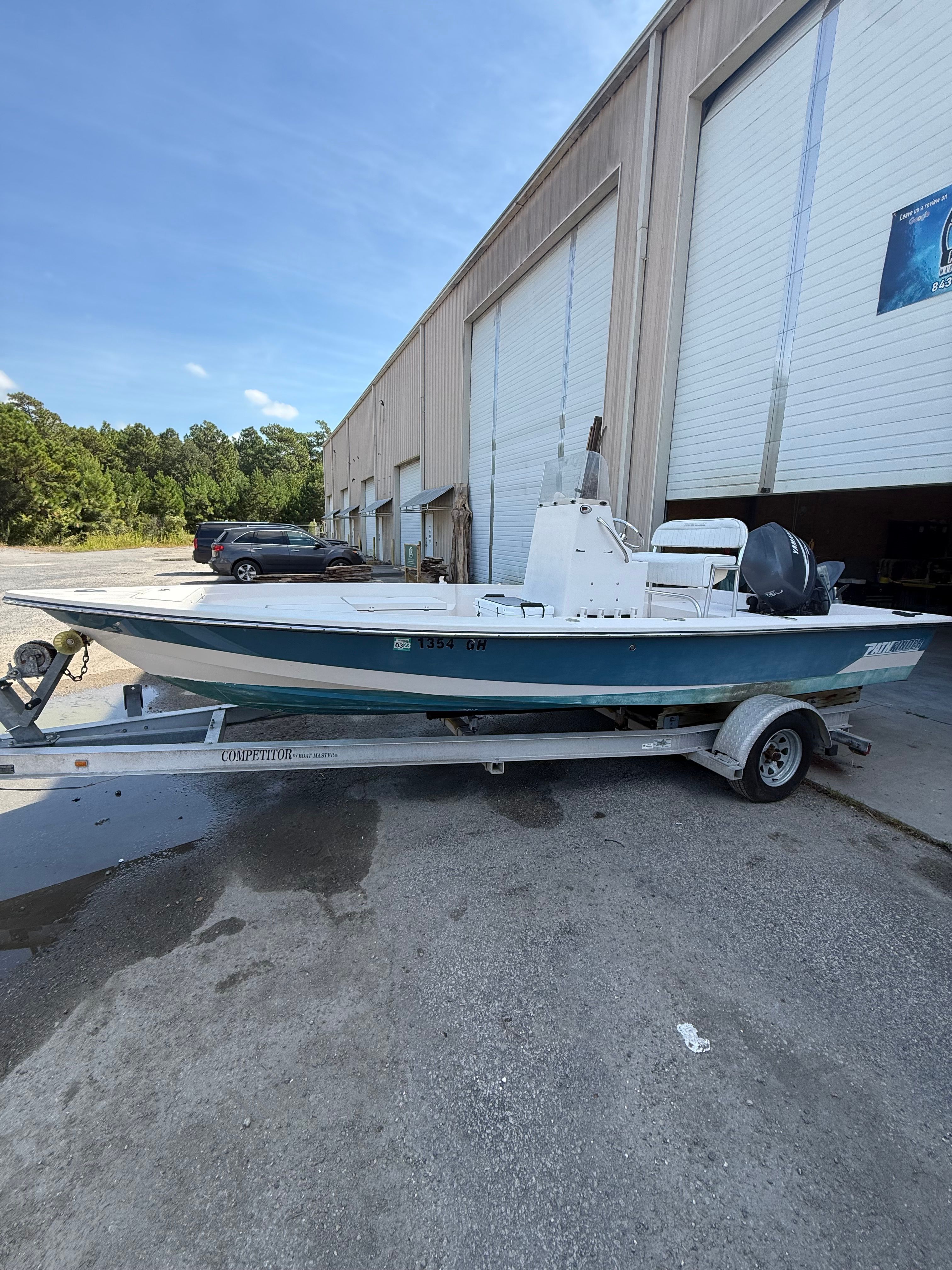 Pathfinder 2000 V 2006 Pathfinder 2000 V boat on trailer outside large warehouse.