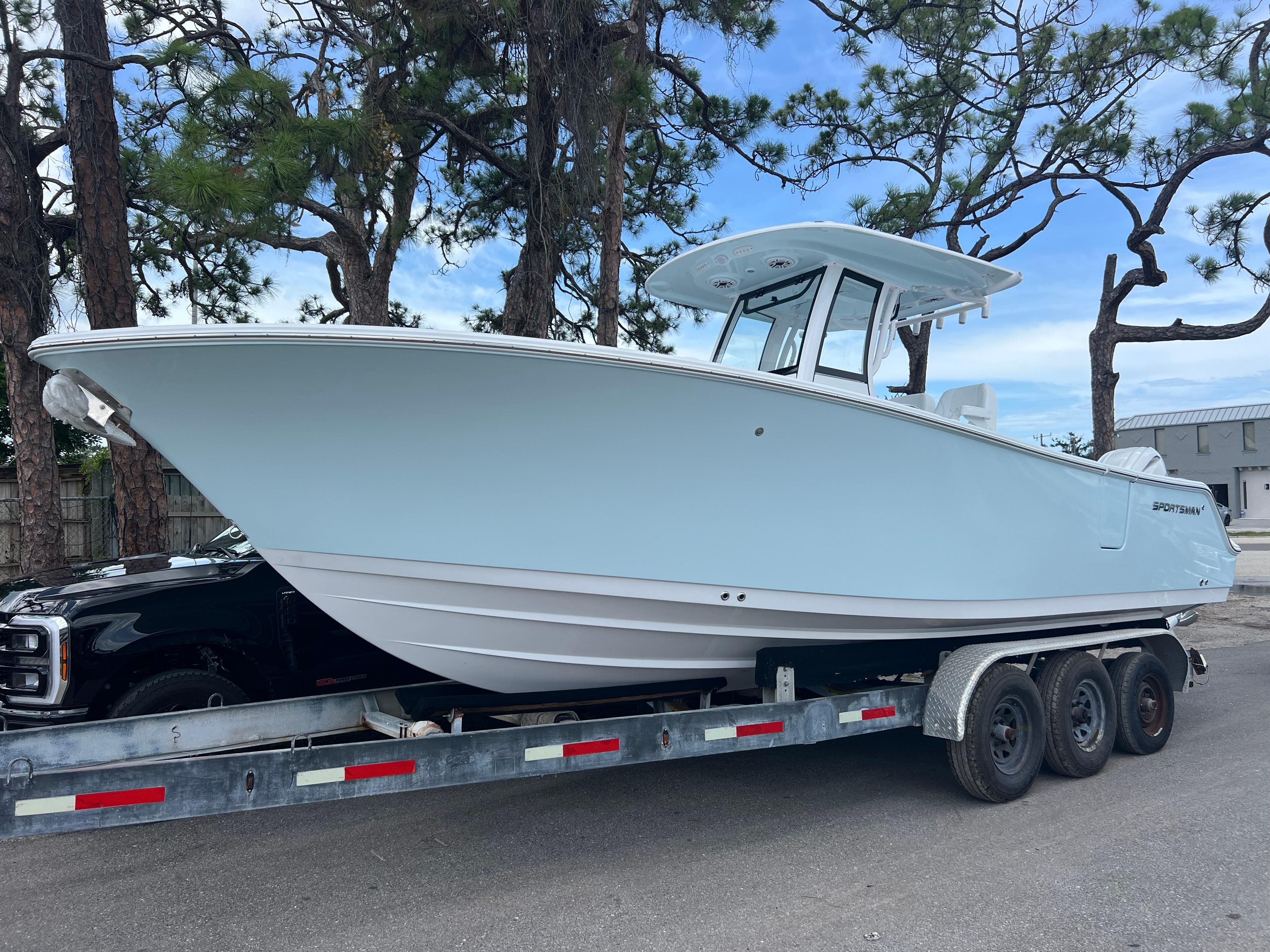 Sportsman Open 262 Center Console 2025 Sportsman Open 262 Center Console boat on trailer, parked near trees.
