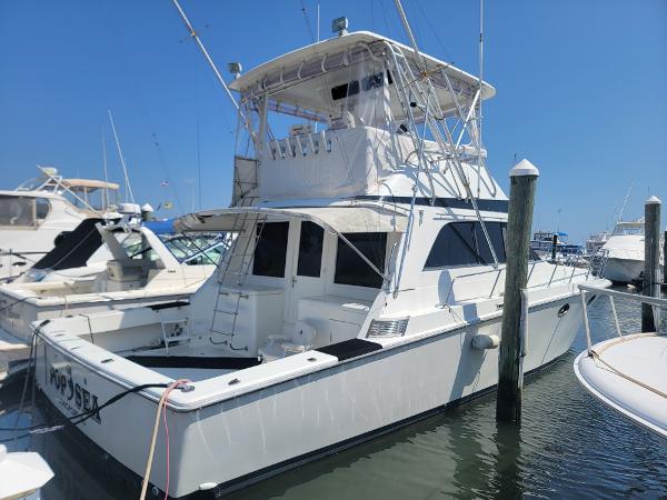 Trojan 46 Sportfish 1989 Trojan 46 Sportfish yacht docked at marina under clear blue sky.
