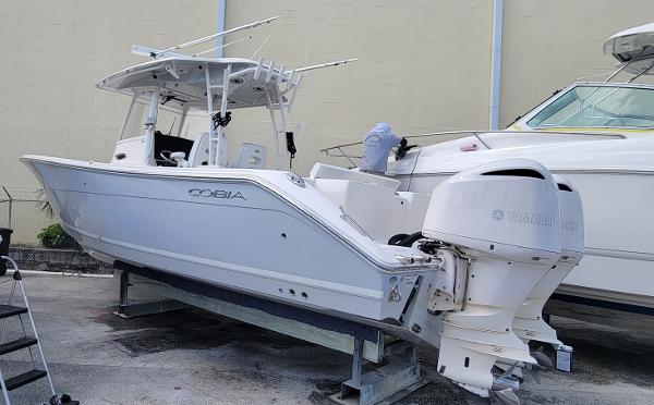 Cobia 320 Center Console 2020 Cobia 320 Center Console boat on display with dual outboard engines.