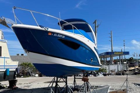 Regal 2660 Express Cruiser 2020 Regal 2660 Express Cruiser boat on stands, blue hull, sunny day.