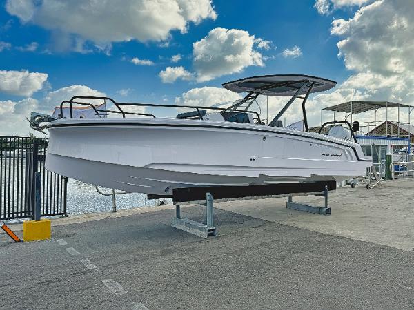 Axopar 25 Cross Top 2025 Axopar 25 Cross Top boat on display at a marina under a blue sky.