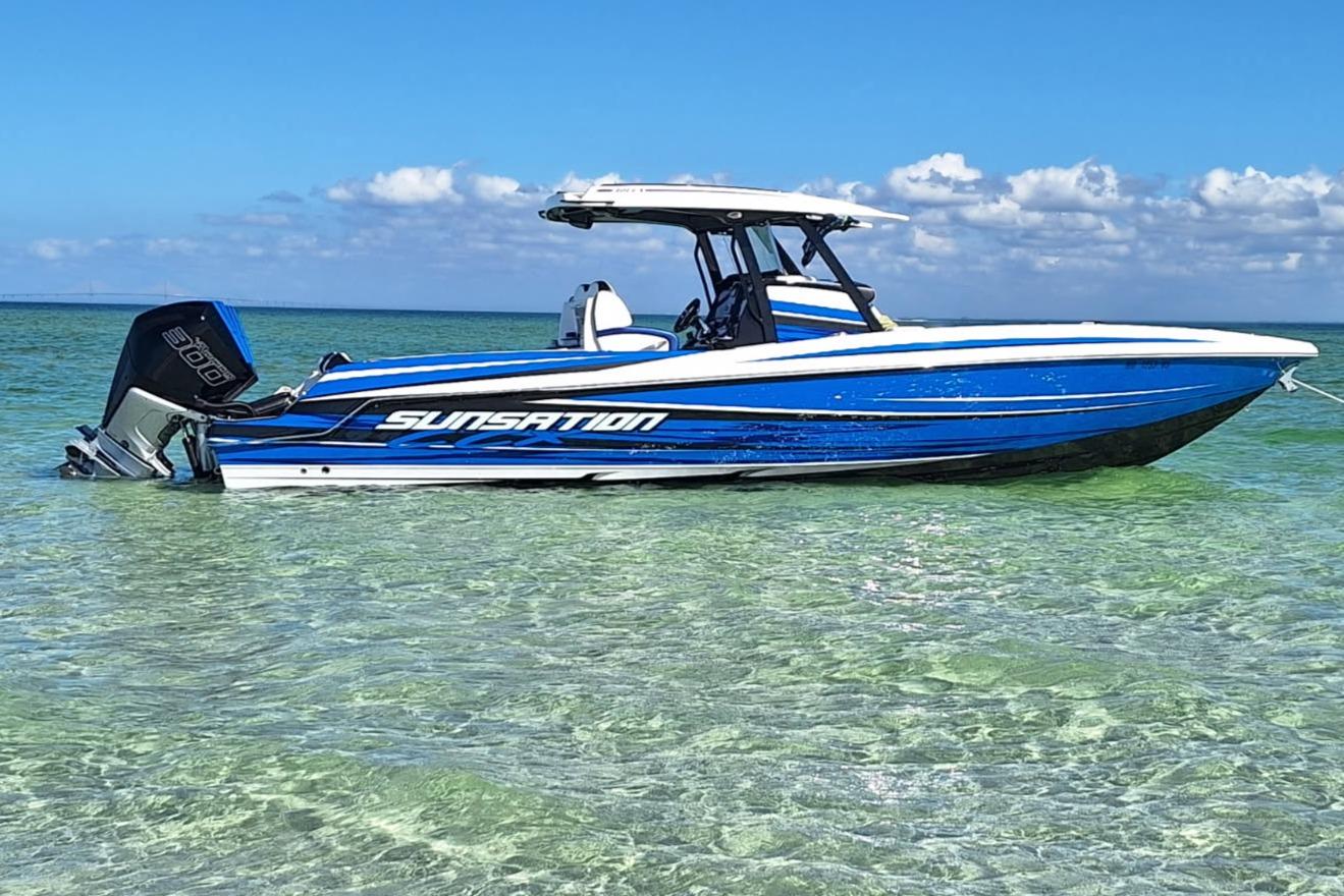 Sunsation 32 CCX 2023 Sunsation 32 CCX boat in clear turquoise water, under a blue sky.