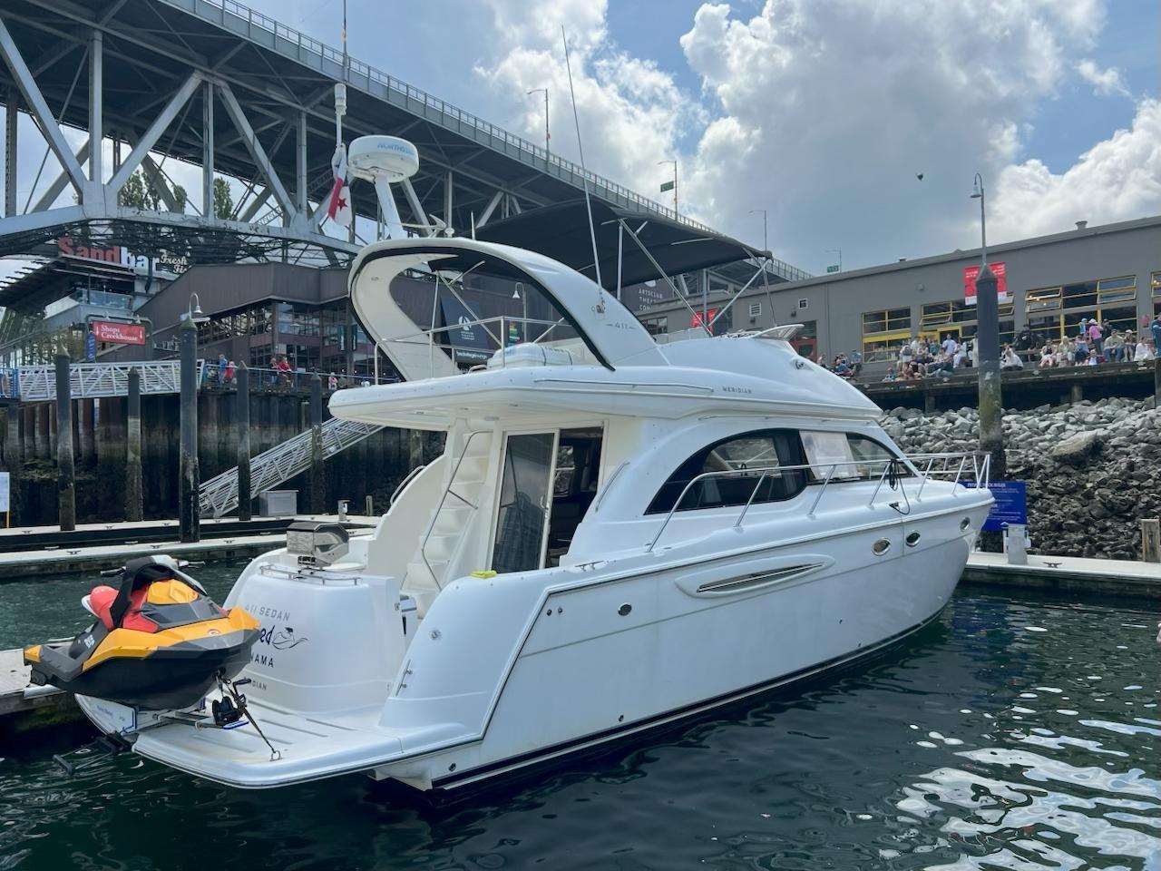 Meridian 411 Sedan Bridge 2008 Meridian 411 yacht docked near a bridge, with a jet ski attached.
