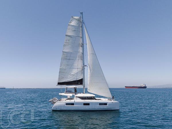Lagoon 46 2021 Lagoon 46 catamaran sailing on open sea with clear blue sky.