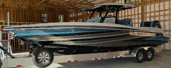 Sunsation 32 CCX 2024 Sunsation 32 CCX boat on trailer in wooden garage.