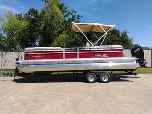 Sun Tracker Party Barge 24 DLX 2024 Sun Tracker Party Barge 24 DLX pontoon boat on a trailer, red and silver.