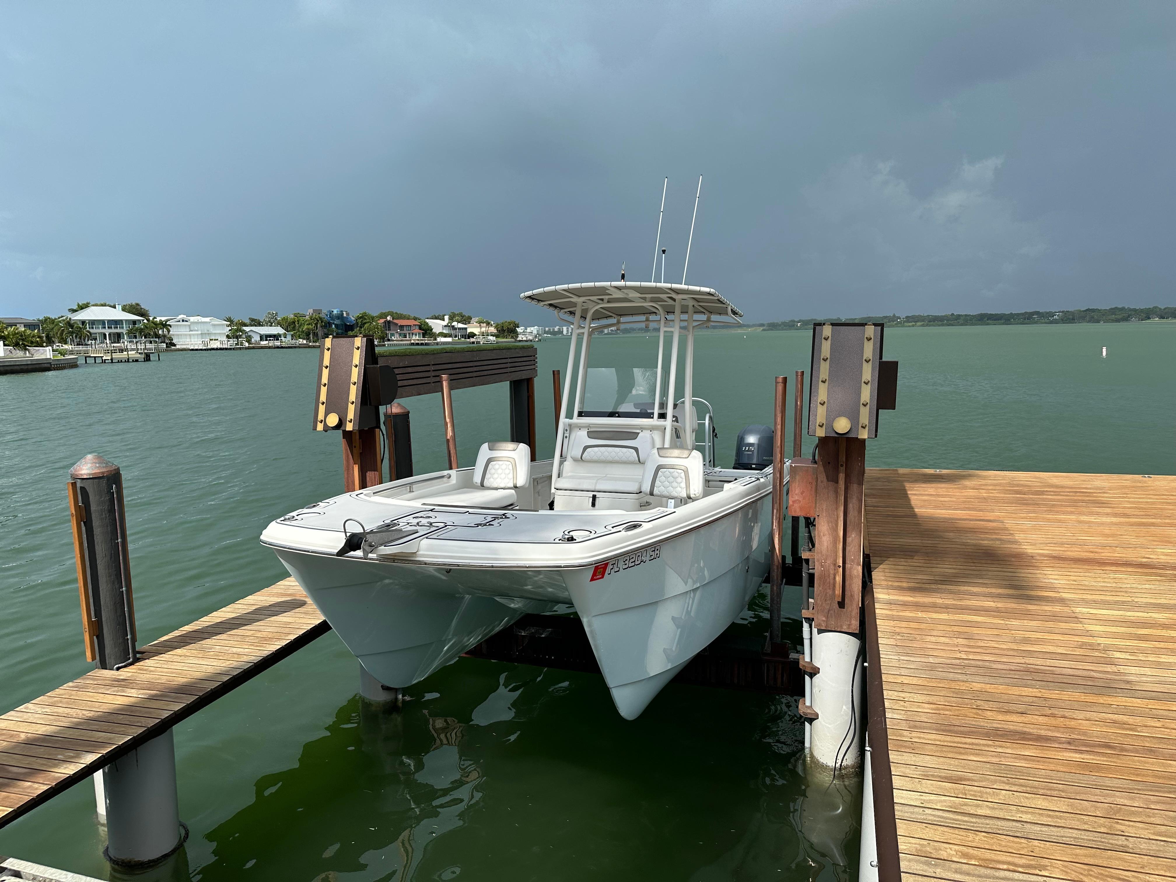 World Cat 230 CC 2019 World Cat 230 CC boat docked on a lift by a wooden pier.