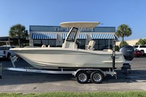 Scout 215 XSF 2026 Scout 215 XSF boat on trailer, parked outside a building with striped awnings.