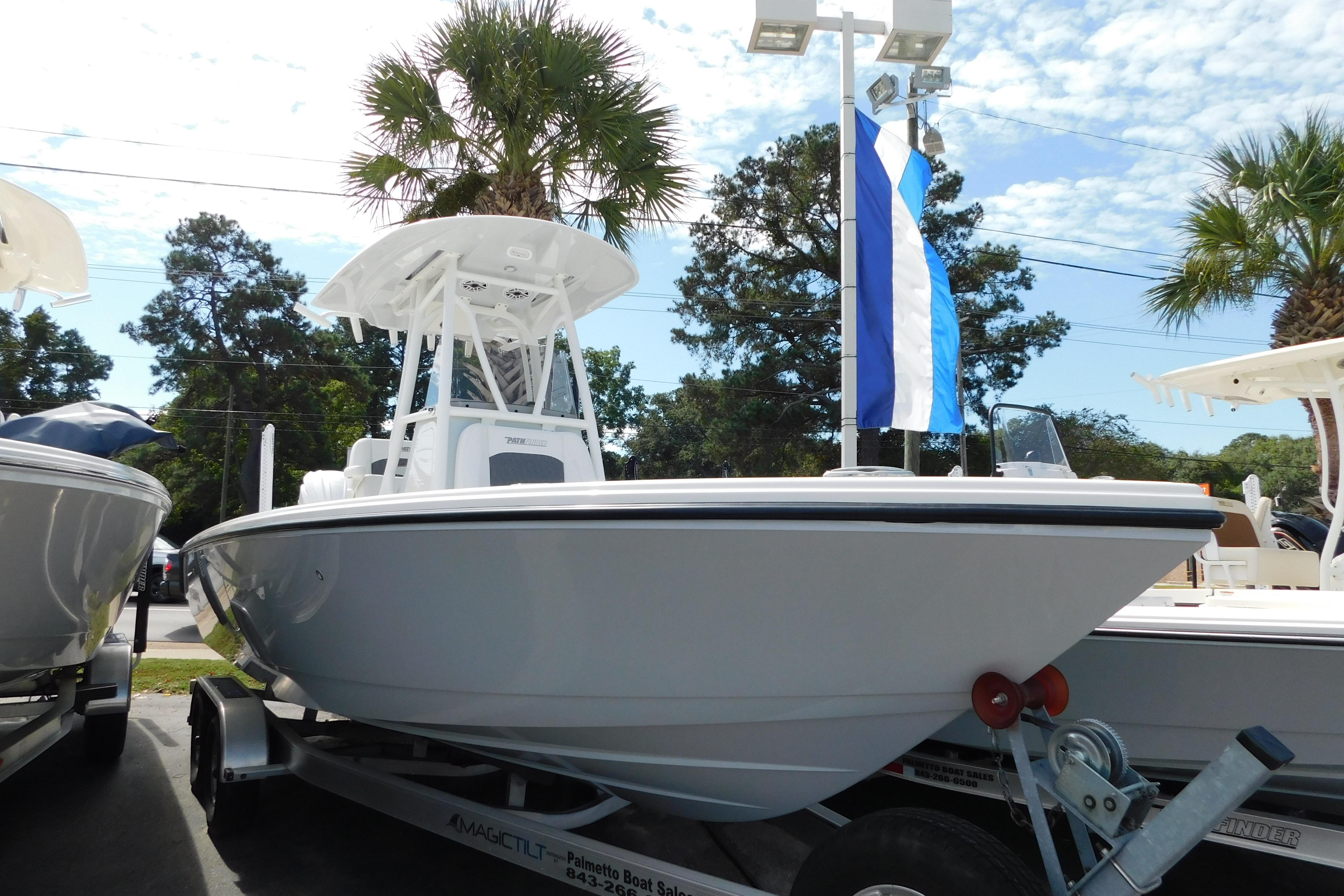 Pathfinder 2400 TRS 2026 Pathfinder 2400 TRS boat on trailer, displayed outdoors with palm trees and blue sky.