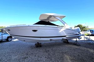 Regal LX9 2026 Regal LX9 boat on display, elevated on stands, under clear blue sky.